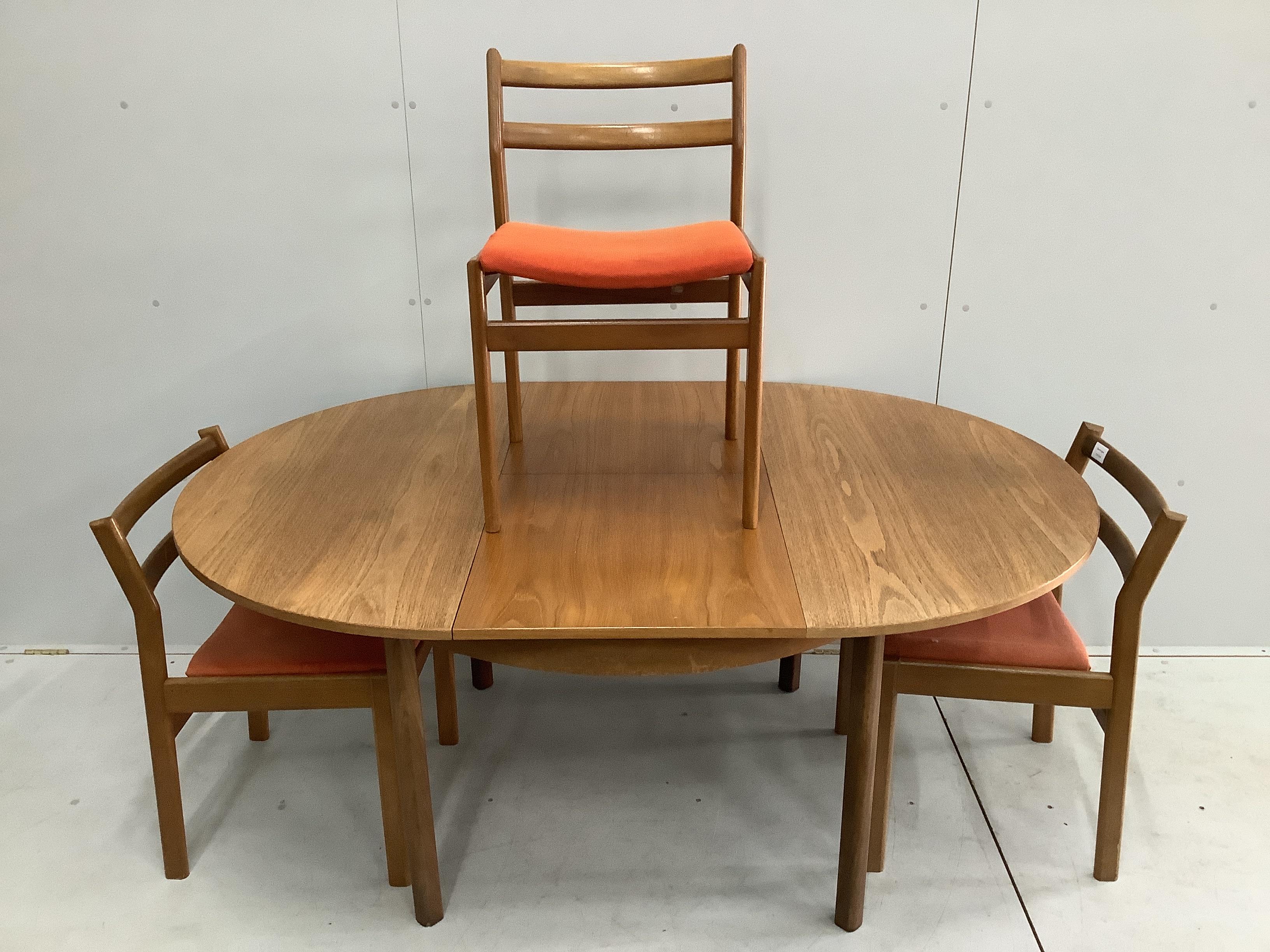A mid century Meredew circular teak extending dining table, diameter 116cm, height 71cm and three mid century teak dining chairs. Condition - fair